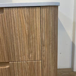 Aulic Varcelli floor standing vanity in woodgrain with a curved edge and pure white stone top, close-up detail