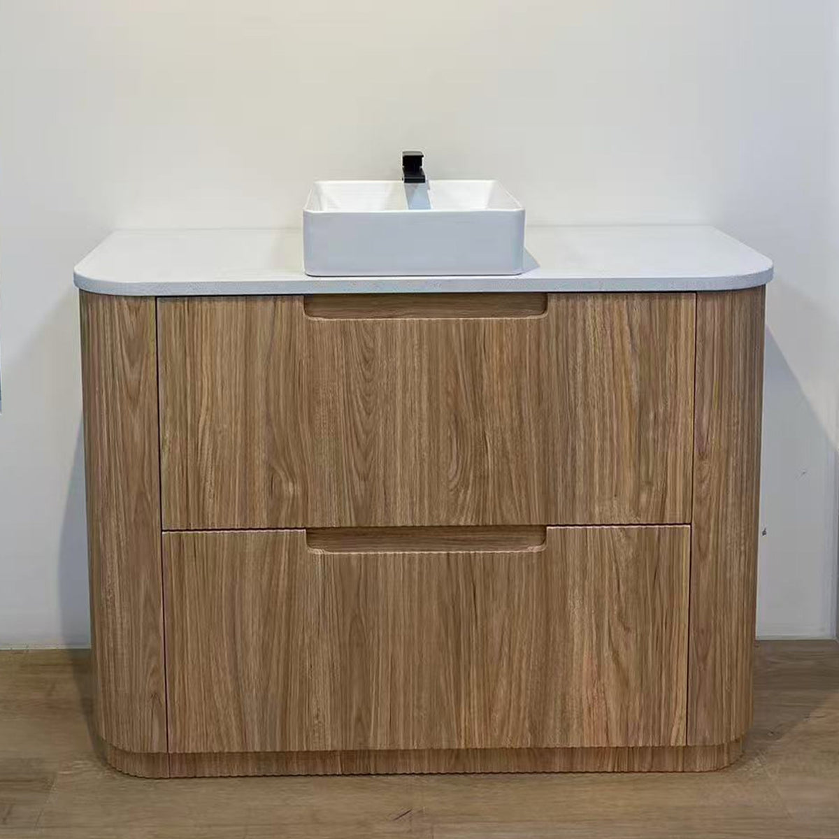 Aulic Varcelli Curve floor standing vanity in Harvest Oak with white flat stone top and vessel basin, front view