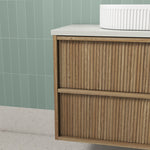 Aulic Venetta fluted wall hung vanity in Harvest Oak with white top, shown close-up in a bathroom setting