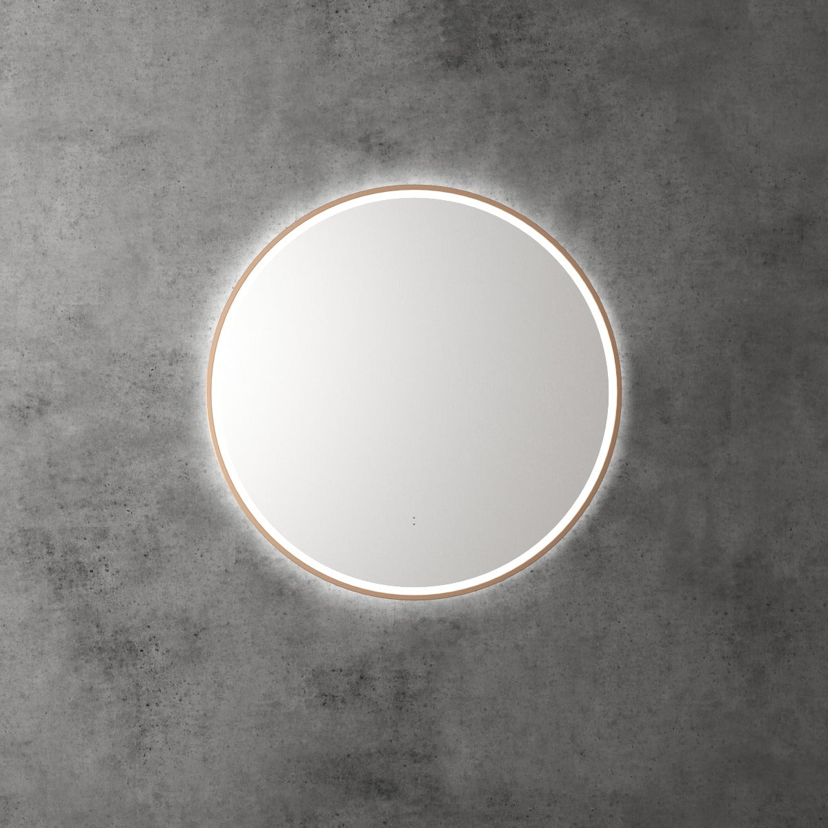 Aulic Windsor round LED mirror with brushed gold frame, front lit and backlit, mounted on a concrete wall