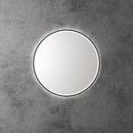 Aulic Windsor round LED mirror with black frame, front-lit and backlit glow, mounted on a concrete wall