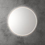 Aulic Windsor round LED mirror with brushed gold frame, front lit and backlit, on grey wall