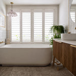 Bao Elegant white acrylic back-to-corner bath in a stylish bathroom, shown beside vanity and window shutters