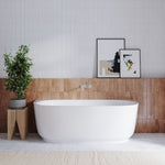 Bao Elegant back to wall bath in gloss white, shown front-on in a modern bathroom setting with wall tiles and artwork