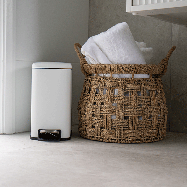 Bao Bath rectangular bathroom pedal bin in matt white, freestanding beside a woven laundry basket in a bathroom setting
