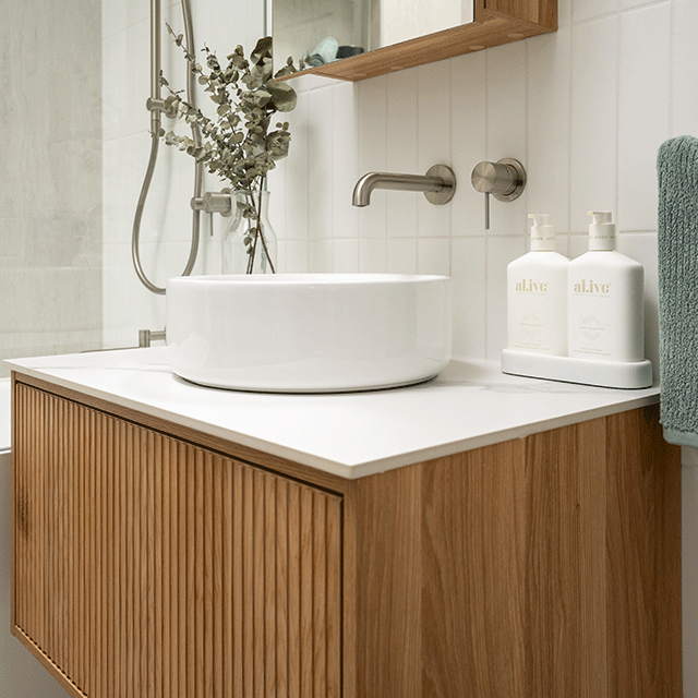 Nero Mecca wall basin mixer with separate back plate in brushed nickel, wall-mounted over a bathroom vanity sink.