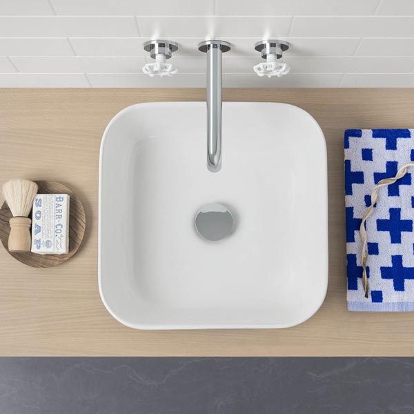 Caroma Artisan white square above-counter basin with chrome waste and mixer tap on timber vanity, top view