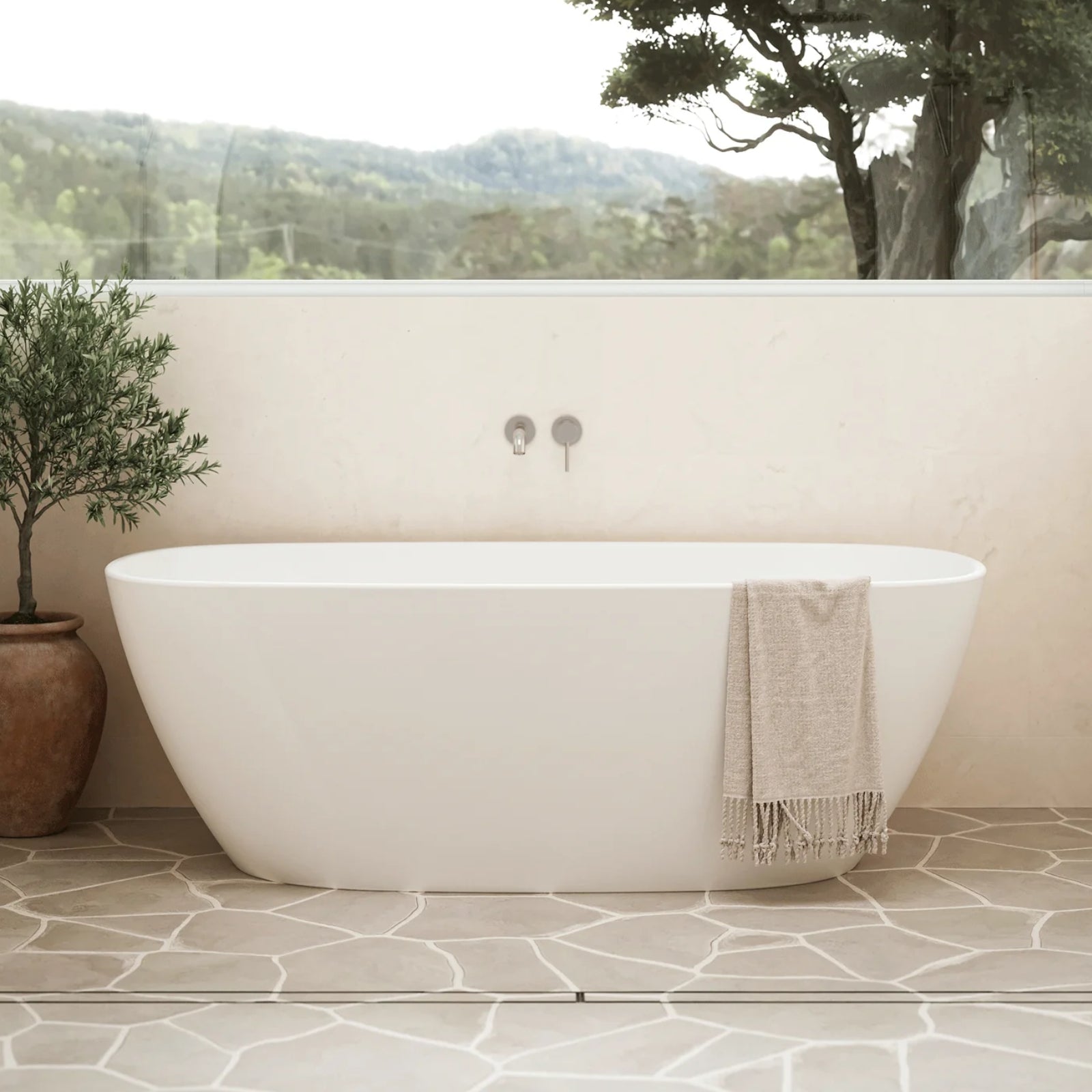 Caroma Contura II matte white freestanding oval bath in a bathroom setting with wall tapware and towel