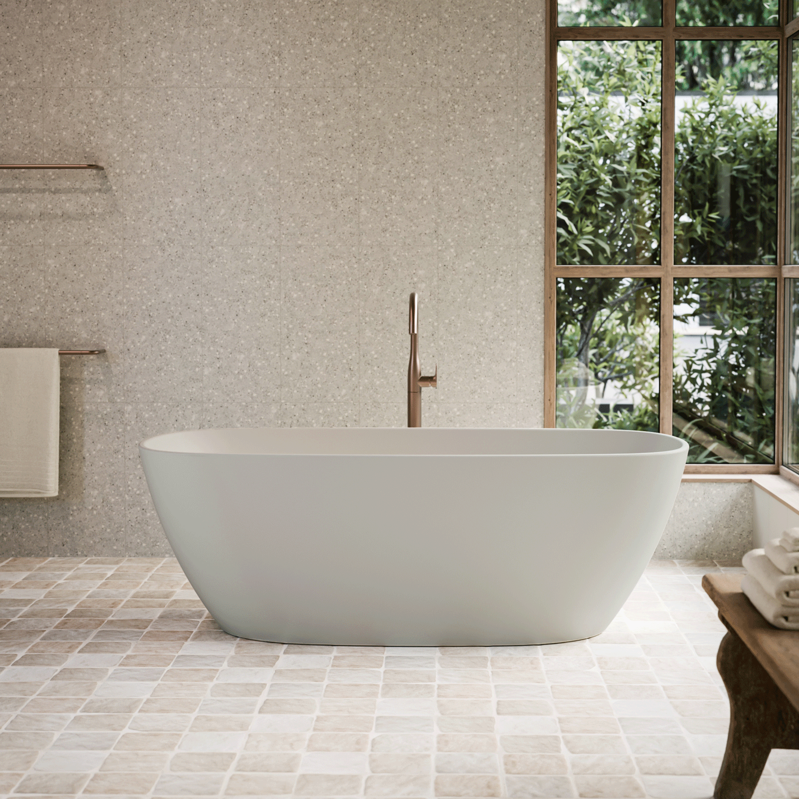Caroma Contura II freestanding oval bath in matte clay, shown in a modern bathroom with window and floor tiles