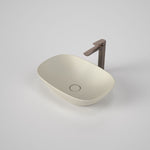 Caroma Contura II above counter basin in matte clay, oval ceramic sink with flush waste and bronze tap shown on a white background