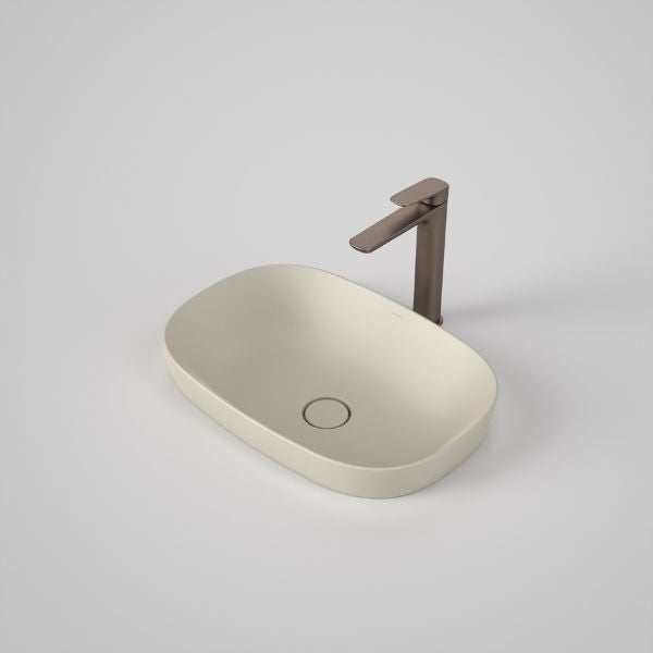 Caroma Contura II matte clay oval inset basin with slim rim and flush waste, shown with a bronze mixer tap on a white background