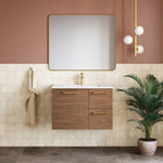 Caroma Contura II basin mixer in matte black, pictured in a modern bathroom vanity setting with a brass-toned tap visible