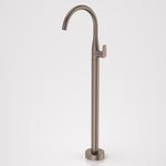 Caroma Contura II freestanding bath filler tap in brushed bronze, floor mounted with curved spout on white background