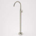 Caroma Contura II floor-mounted bath filler tap in brushed nickel, with tall curved spout on round base