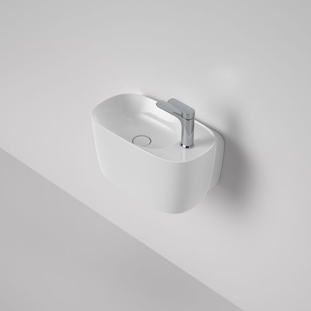 Caroma Contura II white wall hung hand basin with 1 tap hole and round basin waste, angled view