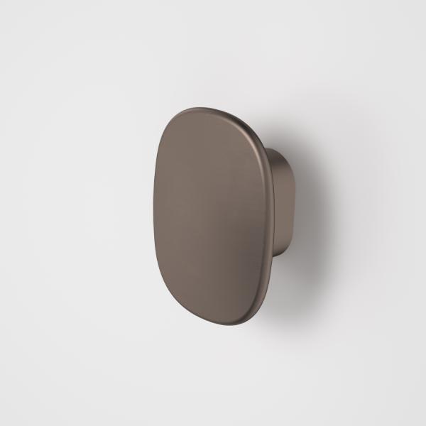 Caroma Contura II small robe hook in brushed bronze, oval wall-mounted bathroom accessory on a light background