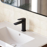 Caroma Contura II matte black basin mixer, hob mounted over a white basin in a modern bathroom setting