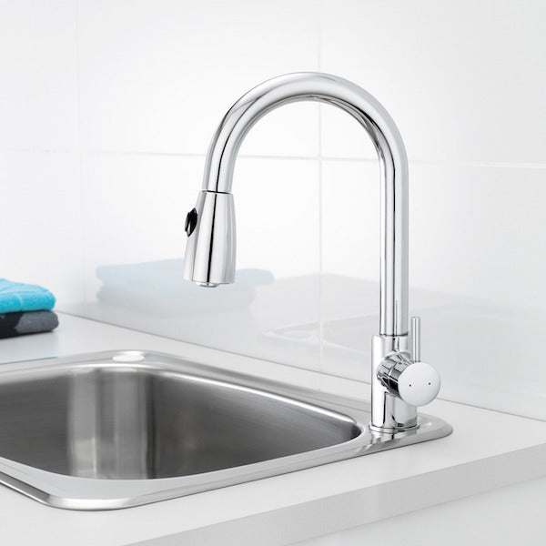 Caroma Husk chrome pull out sink mixer with swivel gooseneck over a stainless steel kitchen sink and white benchtop