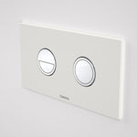 Caroma Invisi Series II round dual flush flush plate, matte white with chrome buttons, wall-mounted view