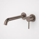 Caroma Liano II wall basin/bath mixer in brushed bronze, with round backplates and curved spout, wall-mounted