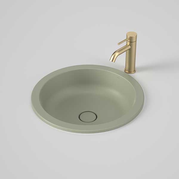 Caroma Liano II round matte green under/over counter basin with waste shown beside a gold tap
