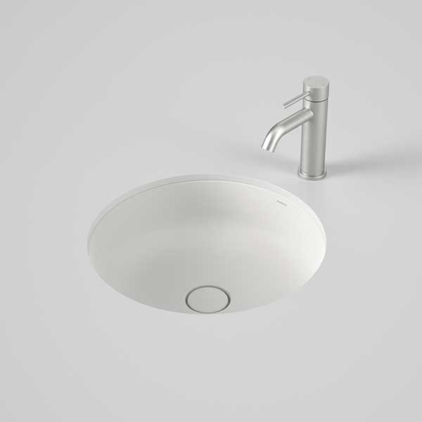 Caroma Liano II round matte white undercounter basin with matching ceramic waste and a chrome mixer tap above
