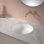 Caroma Liano II round white under-counter basin installed in a grey vanity top with wall-mounted tapware
