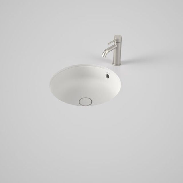 Caroma Liano II round matte white under/over counter basin with overflow, shown with mixer tap on a grey benchtop
