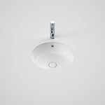 Caroma Liano II round white basin with overflow and chrome waste, shown under counter with tap above on white background