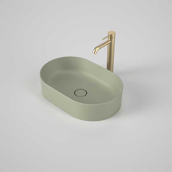 Caroma Liano II matte green pill above counter basin with matching waste and brushed brass tap on a white background