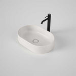 Caroma Liano II oval above-counter basin in matte speckled white, shown with black mixer tap on a vanity-style setting