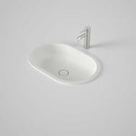 Caroma Liano II pill under counter basin in matte white, with chrome mixer tap on a grey benchtop