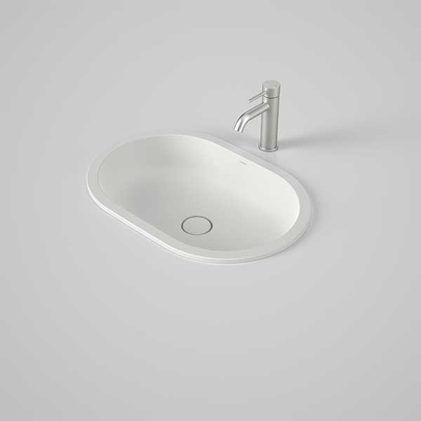 Caroma Liano II pill under counter basin in matte white, with chrome mixer tap on a grey benchtop