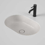 Caroma Liano II oval under counter basin in matte speckled finish with matching plug, shown with black mixer tap on grey background