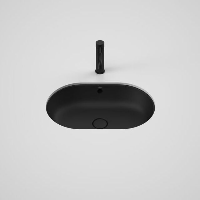 Caroma Liano II matte black oval under/over counter basin with overflow, shown from above with waste plug and dress ring