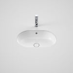 Caroma Liano II white oval under-counter basin with overflow, shown with chrome tapware on a plain background