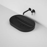Caroma Liano II matte black oval inset basin with tap landing and wall mixer, shown in a modern bathroom setting