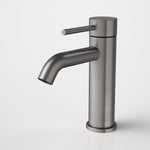 Caroma Liano II basin mixer tap in gunmetal finish, with slim cylindrical body and single lever handle, shown front on