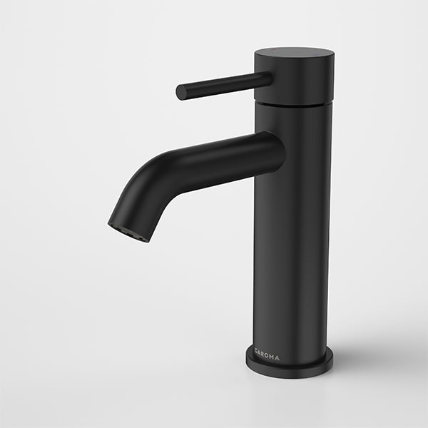 Caroma Liano II basin mixer tap in matte black, slim cylindrical design with curved spout and side lever