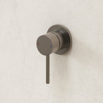 Caroma Liano II wall-mounted bath/shower mixer in gunmetal finish with round handle and matching cover plate