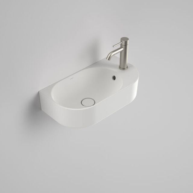 Caroma Liano II wall-hung hand basin in matte white, oval ceramic with single tap hole and overflow, angled view