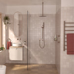 Caroma Liano II heated towel ladder in brushed bronze on a tiled bathroom wall, with towel hanging on the bars