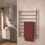 Caroma Liano II heated towel ladder in brushed bronze, wall mounted in a bathroom with a red towel.