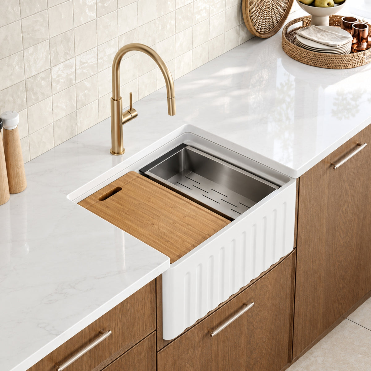Caroma Liano II brushed brass pull out sink mixer over a white kitchen sink and marble-look benchtop among timber cabinetry