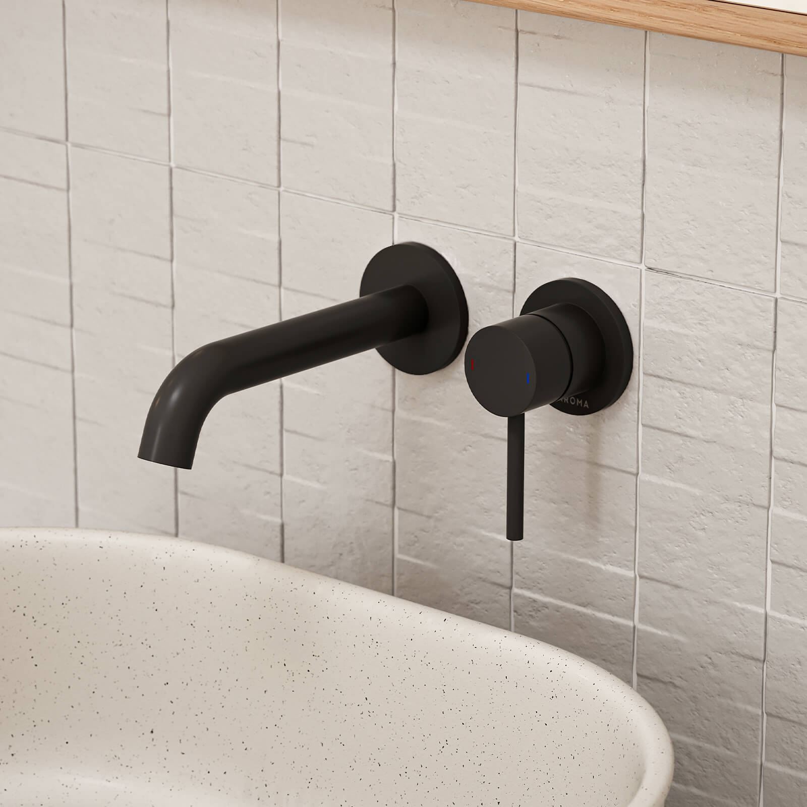 Caroma Liano II wall basin mixer set in matte black, mounted above a white speckled basin on tiled bathroom wall