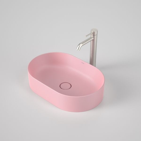 Caroma Liano II pill above counter basin in matte pink, oval ceramic basin with matching waste and tap shown on grey background