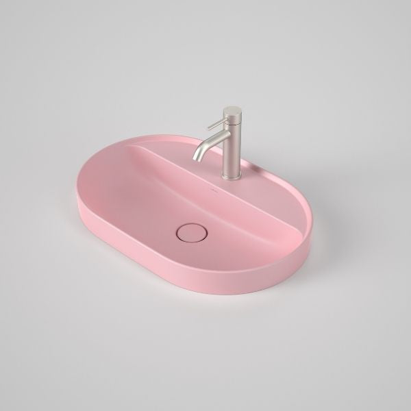 Caroma Liano II oval inset basin in matte pink with tap landing and single tap hole, shown with mixer tap on top