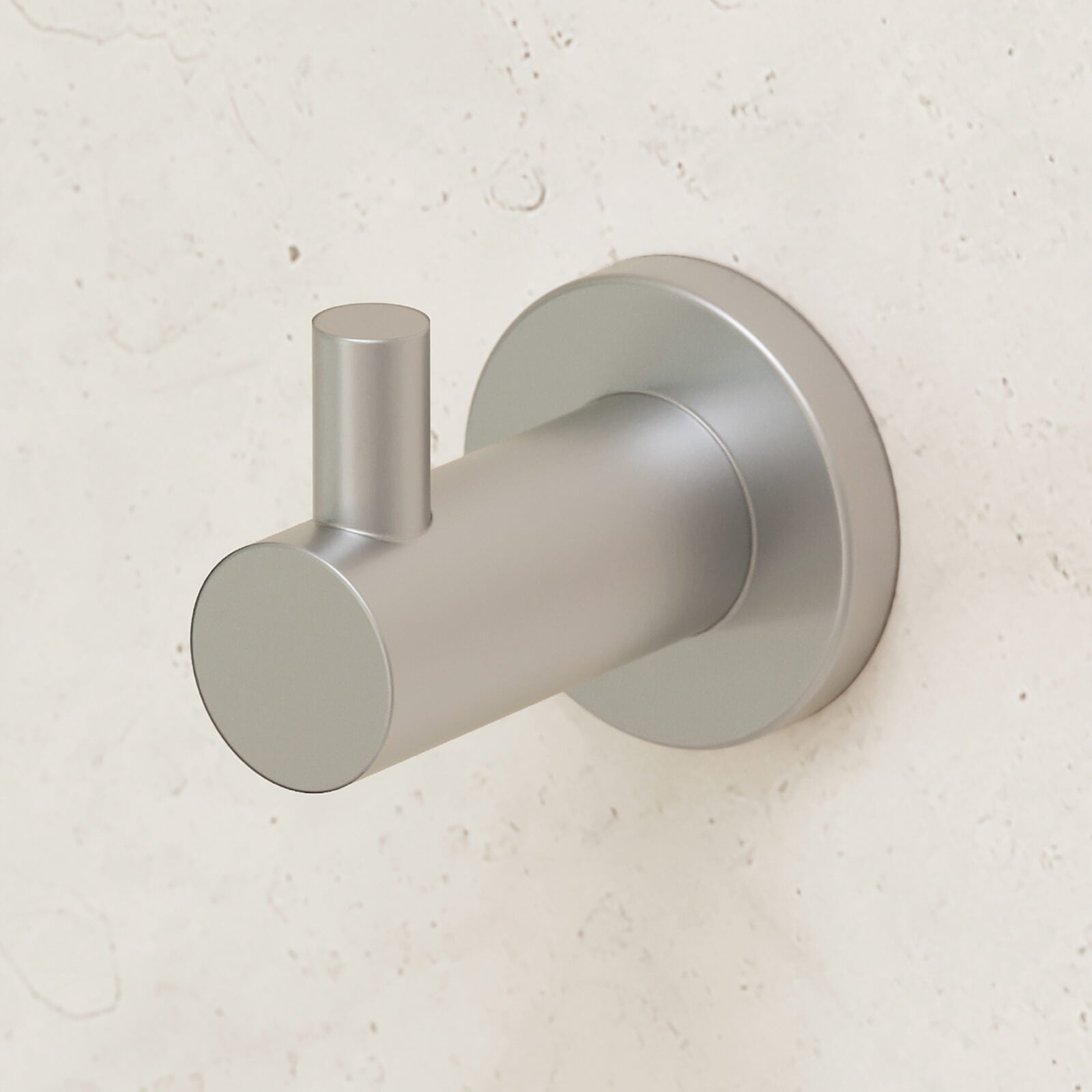 Caroma Liano II robe hook in brushed nickel, shown mounted on a light stone wall.