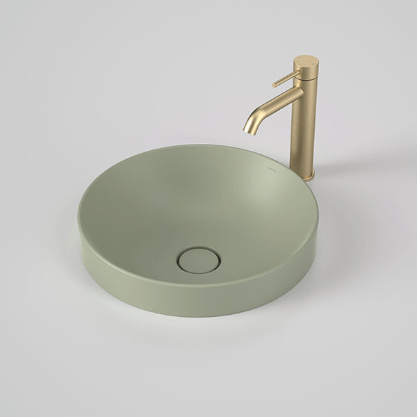Caroma Liano II round inset basin in matte green, shown with a gold mixer tap on a benchtop.