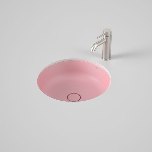 Caroma Liano II round under/over counter basin in matte pink with matching pop-up waste, shown with chrome mixer tap.